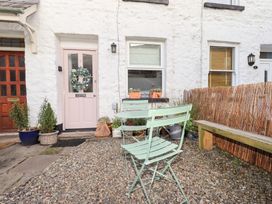 A doorway with a wreath and chairs in front at Gosling Cottage in Kendal