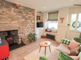 A living room with a fireplace and a sofa at Gosling Cottage Kendal