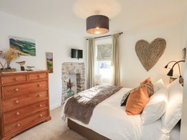 A bedroom with a bed and drawers at Gosling Cottage in Kendal