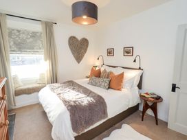 A bedroom with a bed and side tables at Gosling Cottage in Kendal