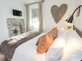 A bedroom with a bed and a TV at Gosling Cottage in Kendal
