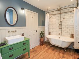 A bathroom with a bathtub and sink at Gosling Cottage in Kendal