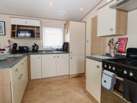 A kitchen with modern appliances and cabinetry at Seashell Lodge, 50 Foxburrow Hang, Belton, Norfolk