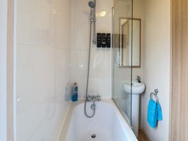 A bathroom with a bathtub and shower at Seashell Lodge, 50 Foxburrow Hang, Belton, Norfolk