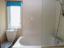 A bathroom with a bathtub and toilet at Seashell Lodge, 50 Foxburrow Hang Belton, Norfolk