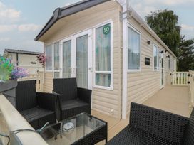 An outdoor area with seating and a table at Seashell Lodge, 50 Foxburrow Hang, Belton, Norfolk