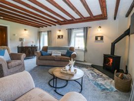 A living room with a sofa and armchair at Bwthyn Derwin Fawr in Garndolbenmaen near Penygroes