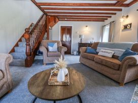 A living room with a sofa and coffee table at Bwthyn Derwin Fawr near Garndolbenmaen