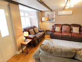 A living room with two sofas and a lamp at The Golden Cross Cottage Evesham
