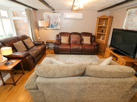 A living room with sofas and a television at The Golden Cross Cottage in Evesham