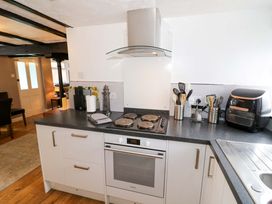 A kitchen with a cooker, oven, and kitchen utensils at The Golden Cross Cottage in Evesham