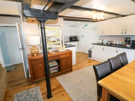 A kitchen with a dining area and various appliances at The Golden Cross Cottage in Evesham
