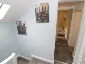 A hallway with paintings on the wall and access to a room at The Golden Cross Cottage in Evesham