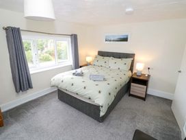 A bedroom with a bed, nightstand, and window at The Golden Cross Cottage Evesham