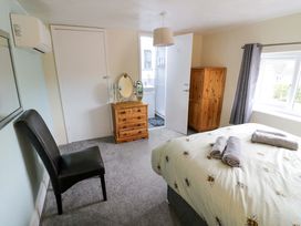 A bedroom with a bed and a dressing table at The Golden Cross Cottage in Evesham