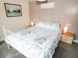 A bedroom with a bed and bedside table at The Golden Cross Cottage Evesham