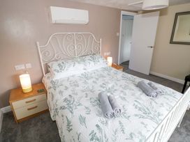 A bedroom with a bed and bedside table at The Golden Cross Cottage in Evesham