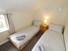 A bedroom with two single beds and a lamp at The Golden Cross Cottage in Evesham
