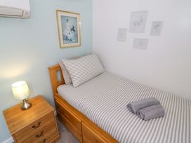A bedroom with a single bed and a nightstand at The Golden Cross Cottage in Evesham
