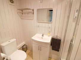 A bathroom with a sink, toilet and shower at The Golden Cross Cottage Evesham