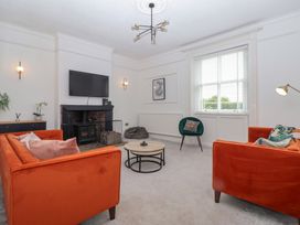 A living room with an orange sofa and coffee table at The Grange in Flamborough