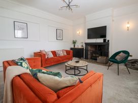 A living room with sofas, a table, and a television at The Grange in Flamborough