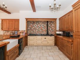 A kitchen with wooden cabinets and an oven at The Grange in Flamborough