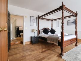 A bedroom with a four-poster bed and attached bathroom at The Grange in Flamborough