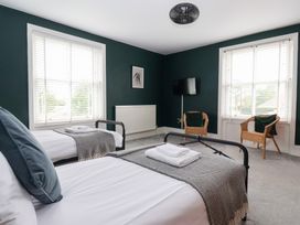 A bedroom with two beds and a television at The Grange in Flamborough