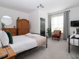 A bedroom with two beds, wardrobe, and television at The Grange in Flamborough