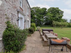 An outdoor dining area with a barbecue grill and table at The Grange in Flamborough