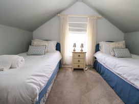 A bedroom with two twin beds separated by a small nightstand with two lamps at Branwen in Talacre
