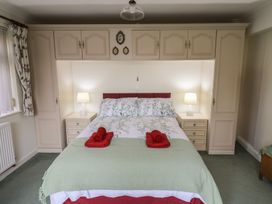 A bedroom with a double bed flanked by two bedside tables with lamps at Woodstock in Chaffcombe near Chard