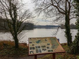 An outdoor informational sign near a reservoir with trees and water in the background at Woodstock in Chaffcombe near Chard