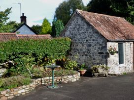 A shed next to a garden with a birdbath at Woodstock in Chard