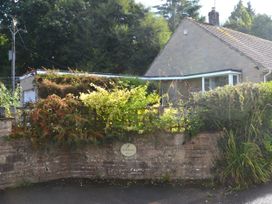 A house with a garden and a sign at Woodstock in Chard