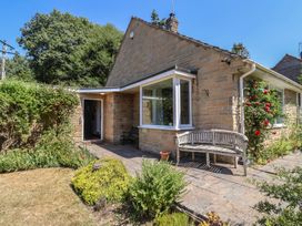 An outdoor area of a house with a bench and garden at Woodstock in Chard