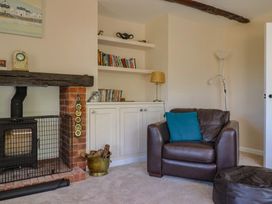 A living room with a fireplace and bookshelf at Woodstock in Chard