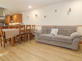 A dining room with a table and chairs and a sofa at Ash Barn in Falmouth