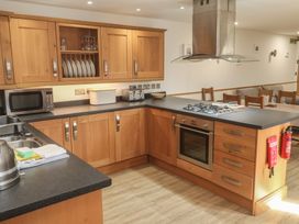 A kitchen with cabinets and appliances at Ash Barn in Falmouth