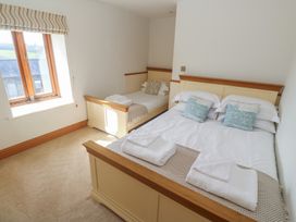 A bedroom with two beds and a window at Ash Barn in Falmouth