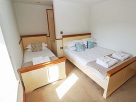 A bedroom with a single bed and a double bed at Ash Barn in Falmouth