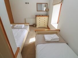 A bedroom with two beds and a dresser at Ash Barn in Falmouth