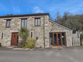 A building with stone walls and wooden doors at Ash Barn in Falmouth