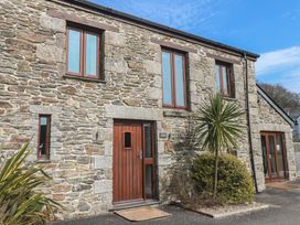 A stone house exterior with windows and a door at Ash Barn in Falmouth