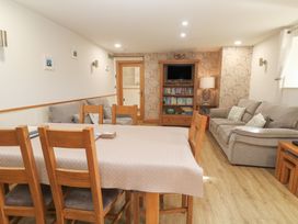 A living room with a dining table and sofa at Ash Barn in Falmouth