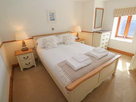 A bedroom with a bed and bedside table at Ash Barn in Falmouth