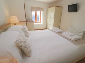 A bedroom with a bed and wardrobe at Ash Barn in Falmouth