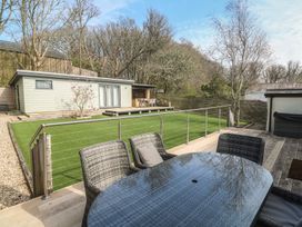 A garden with a table and chairs overlooking a building at Ash Barn in Falmouth