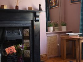 A living room with a fireplace and plants on a cabinet at 33 High Street Fortuneswell